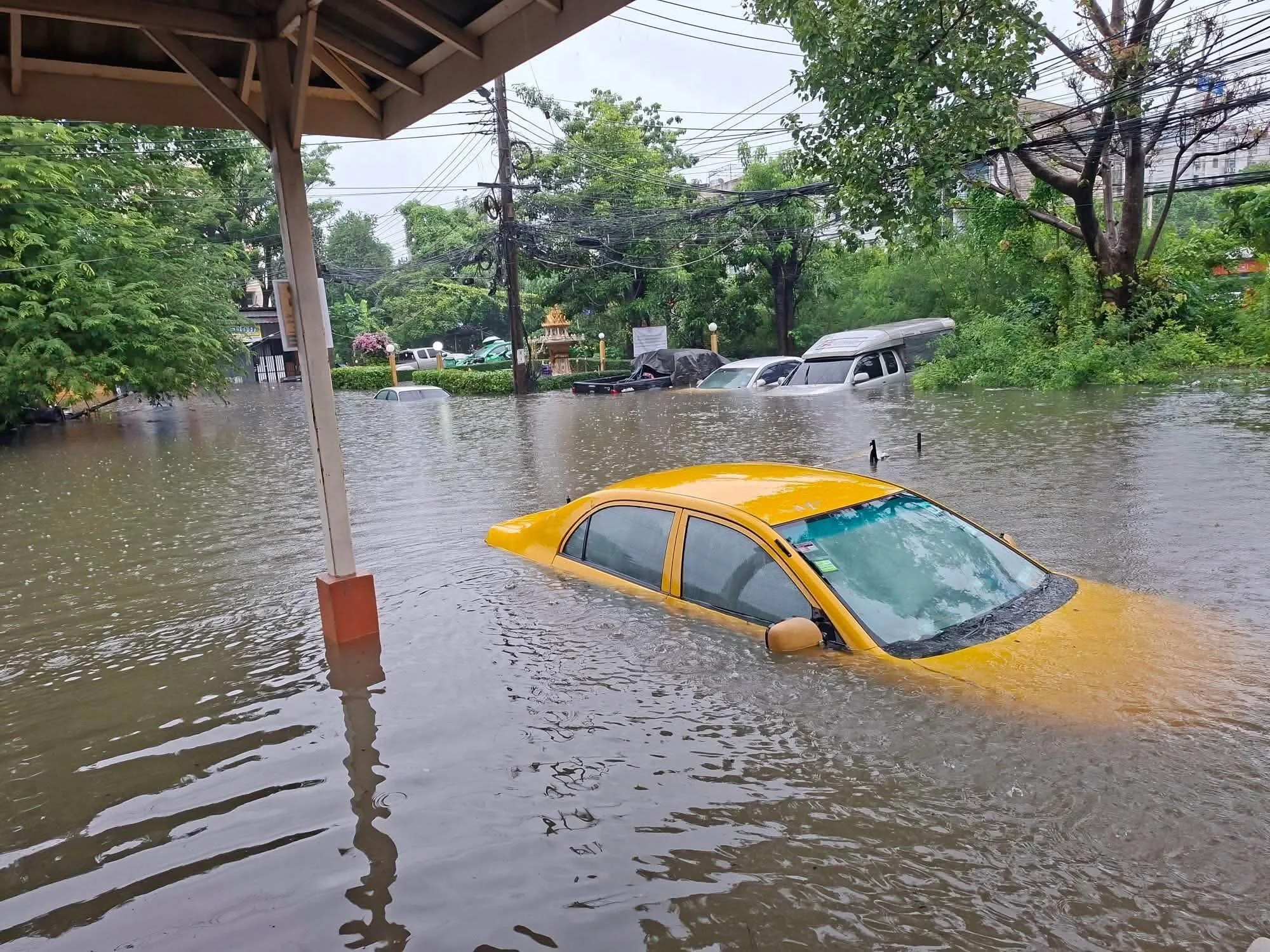 Chiếc xe ô tô màu vàng bị ngập sâu giữa biển nước trong hình ảnh lũ lụt