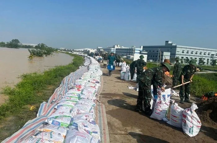 Bộ đội và người dân đắp đê bao cát chống lũ lụt ven bờ nước dâng