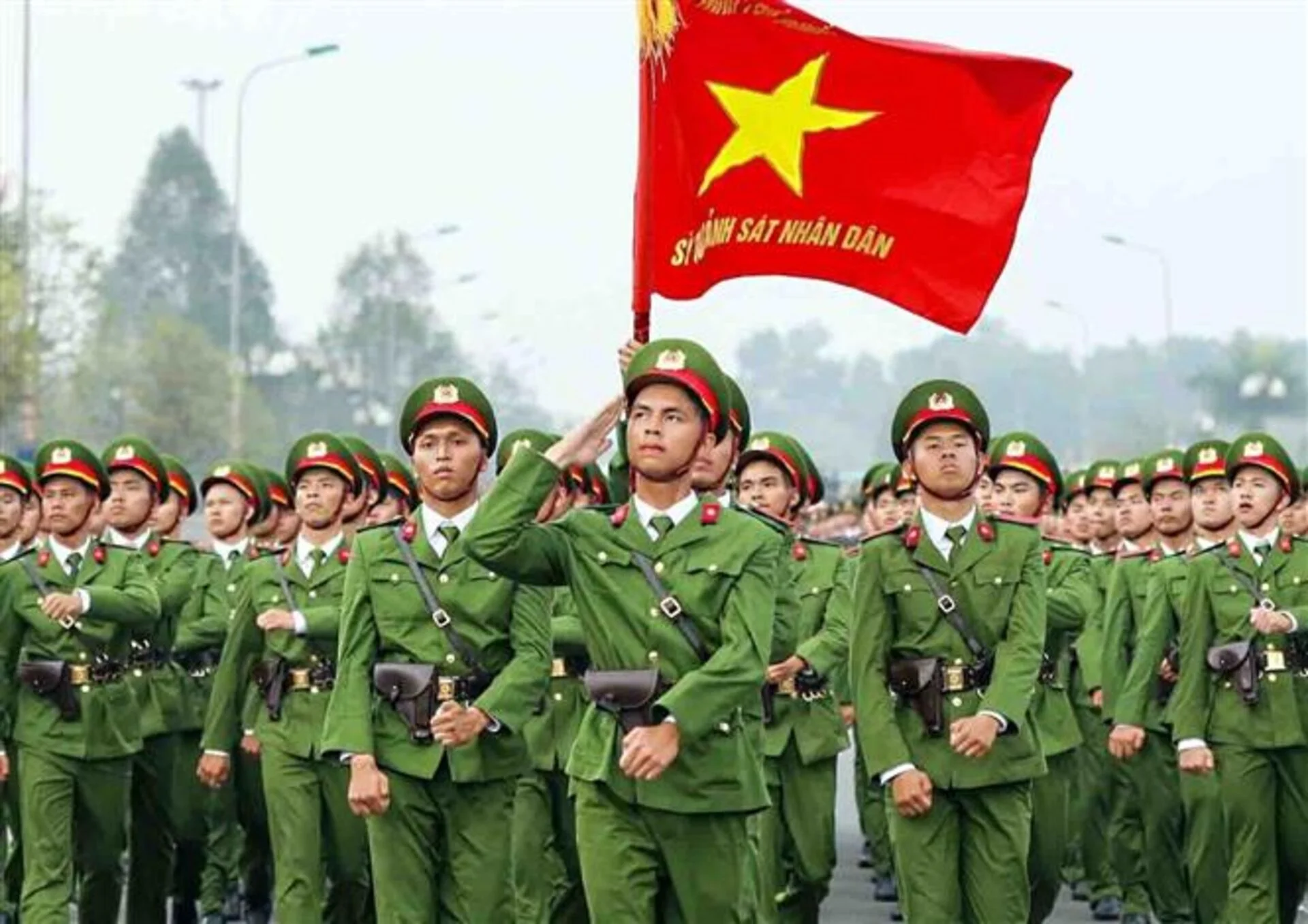 Ảnh công an nhân dân Việt Nam đang diễu binh với lá cờ đỏ sao vàng.